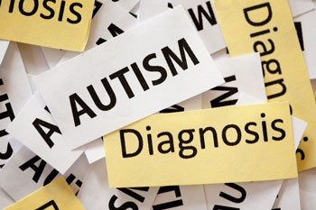 small pieces of paper in a pile with the words autism and diagnosis on top