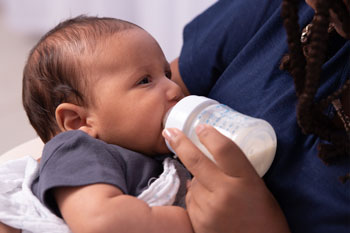Mother feeding bottle to infant.