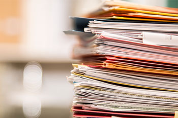 A stack of student folders against a blurred background.