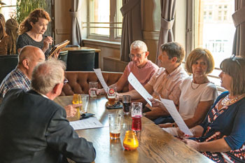 Older adults sitting a a restaurant table review menus.