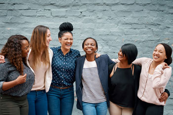 A line of six young women laughing and talking.
